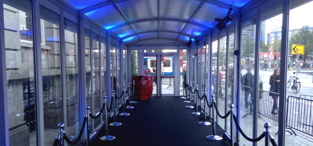 Zeltverleih Intertent - Pergola Walkway mit Glasfassaden, Innenansicht - Roter Teppich für Empfang der Gäste und Vips mit Abkordelungen