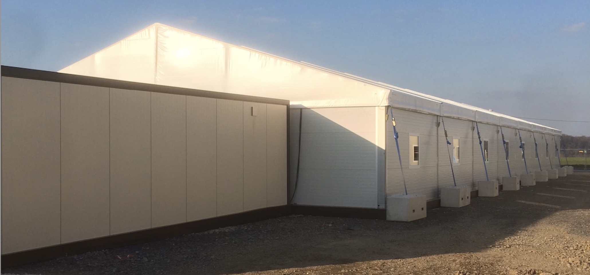 Zeltverleih Intersettle - Zeltanlage und Wohncontainer als Unterkunft für Asylbewerber, Flüchtlinge - Außenansicht Zelthalle