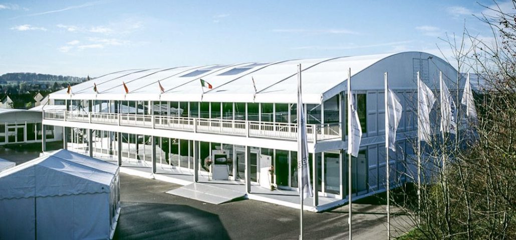 Doppelstockzelt mit überdachter Außenterrasse und Balkon an der Längsseite für Messen und Firmenevents - Intersettle Zeltvermietung aus NRW