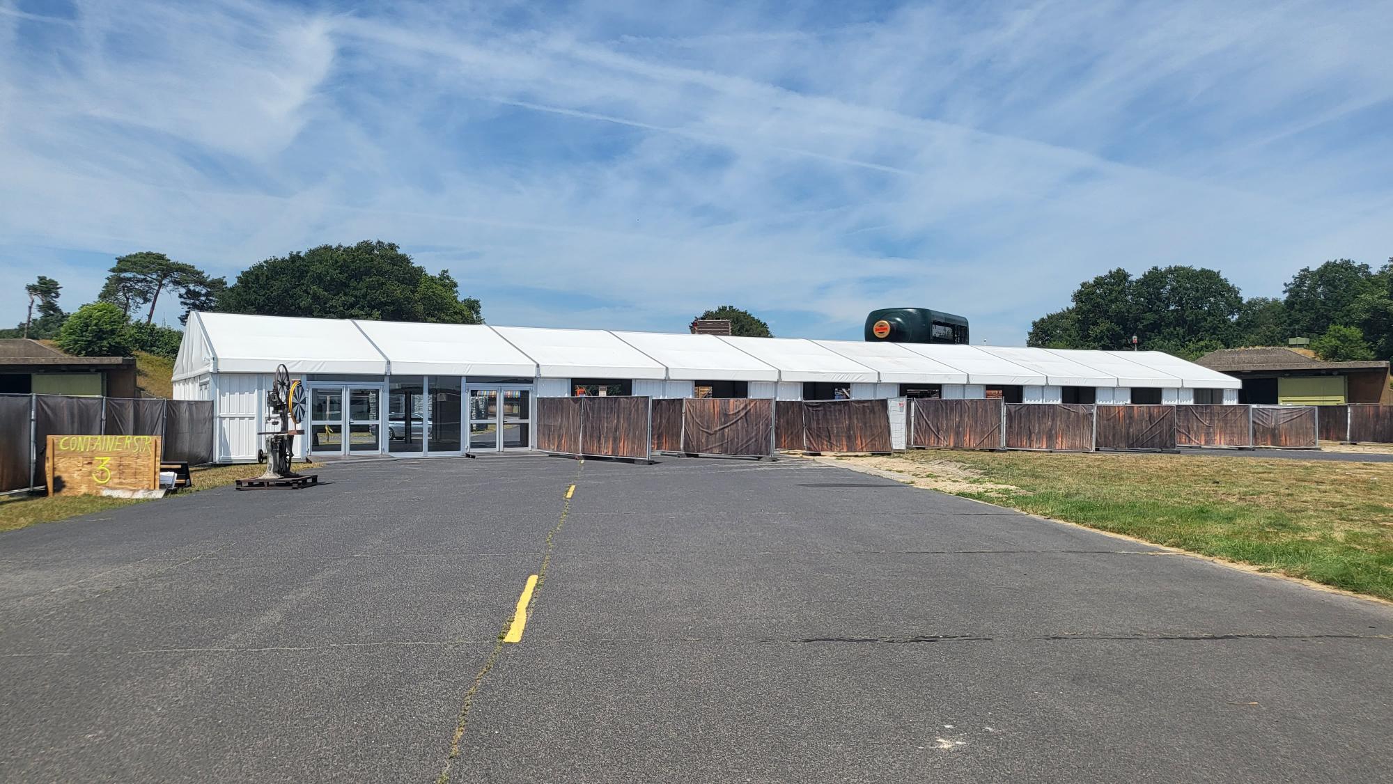 Zelthalle von Intersettle Zeltverleih - Eventzelt Alu Pavillon mit Glastüren als Zugang zum Festivalgelände von Parookaville in Weeze 2022