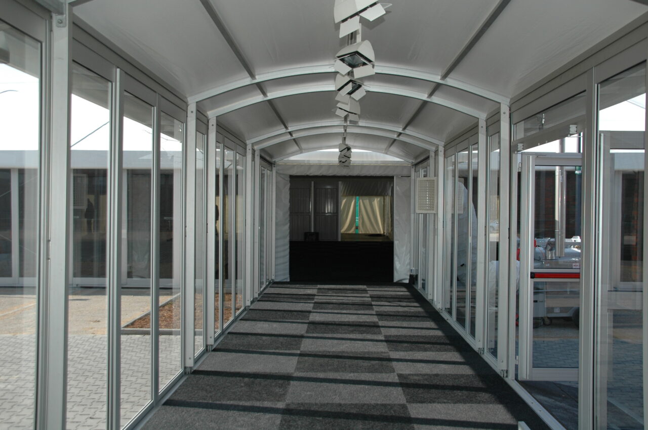 Zeltverleih Intersettle - Pergola Walkway zur Verbindung von Gebäuden und Zelten - Eleganter, schützender Übergang mit Seitenwänden aus Glas mit Panoramaausblick