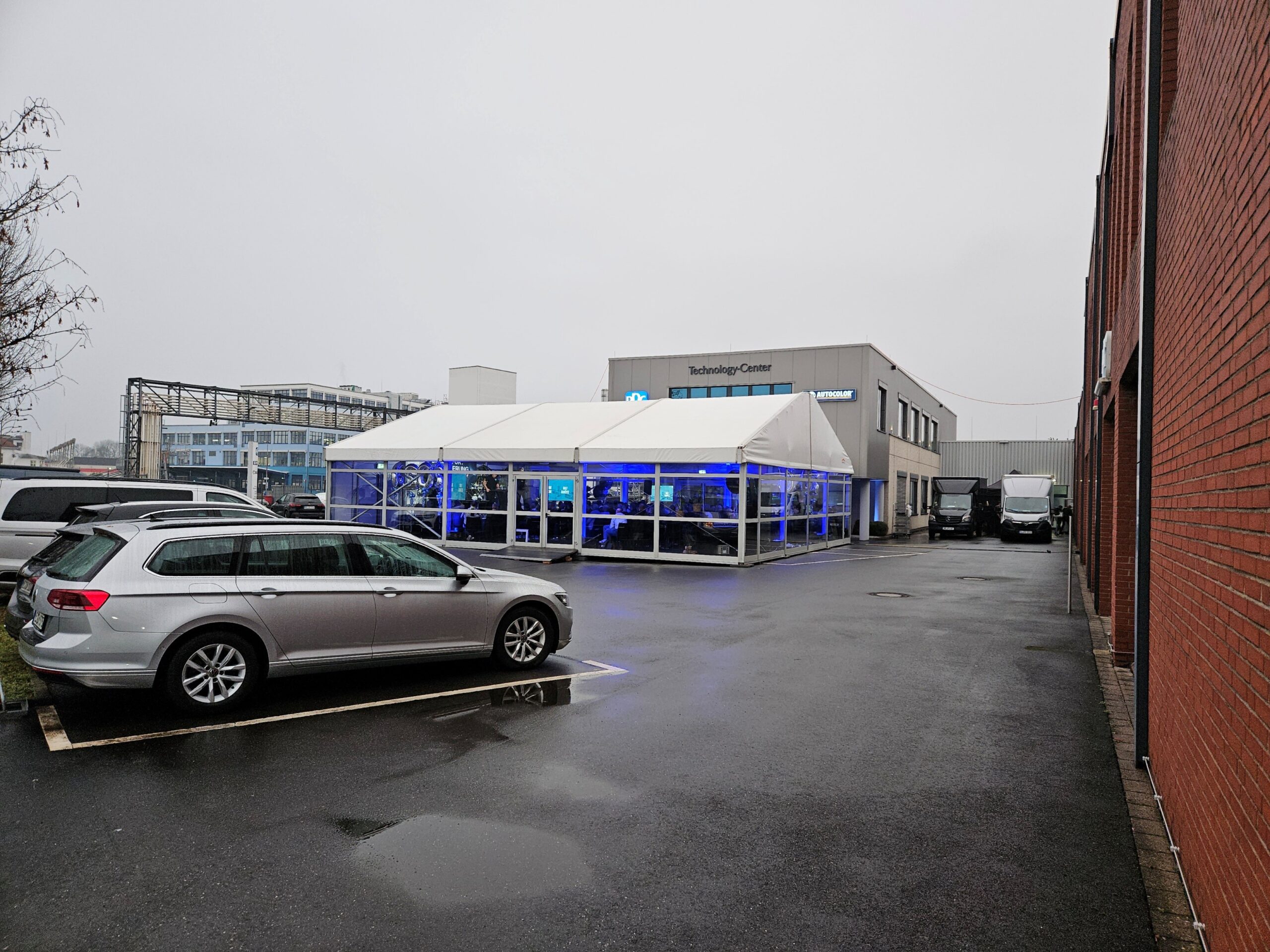 Raumlösung für Tagungen und Kongresse - Zelthalle Alu Vision (12x15m) mit horizontalen Glasfassaden von Intersettle Zeltverleih und Pergola Walkway für direkten Übergang ans Firmengebäude