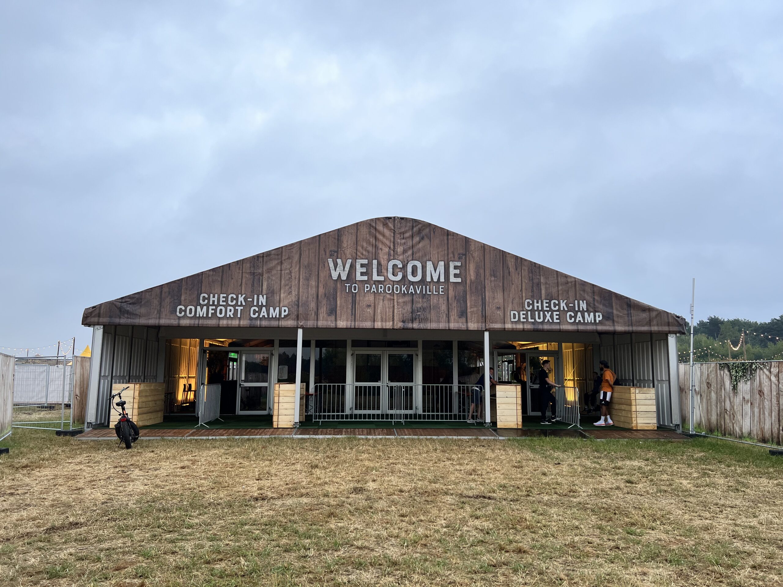 Zeltverleih Intersettle - Zelthalle zum Empfang der Besucher - parookaville-festival-2022-comfort-camp-deluxecamp-Mietbäume-mietpflanzen-welcomecounter-loungemöbel-empfangstresen