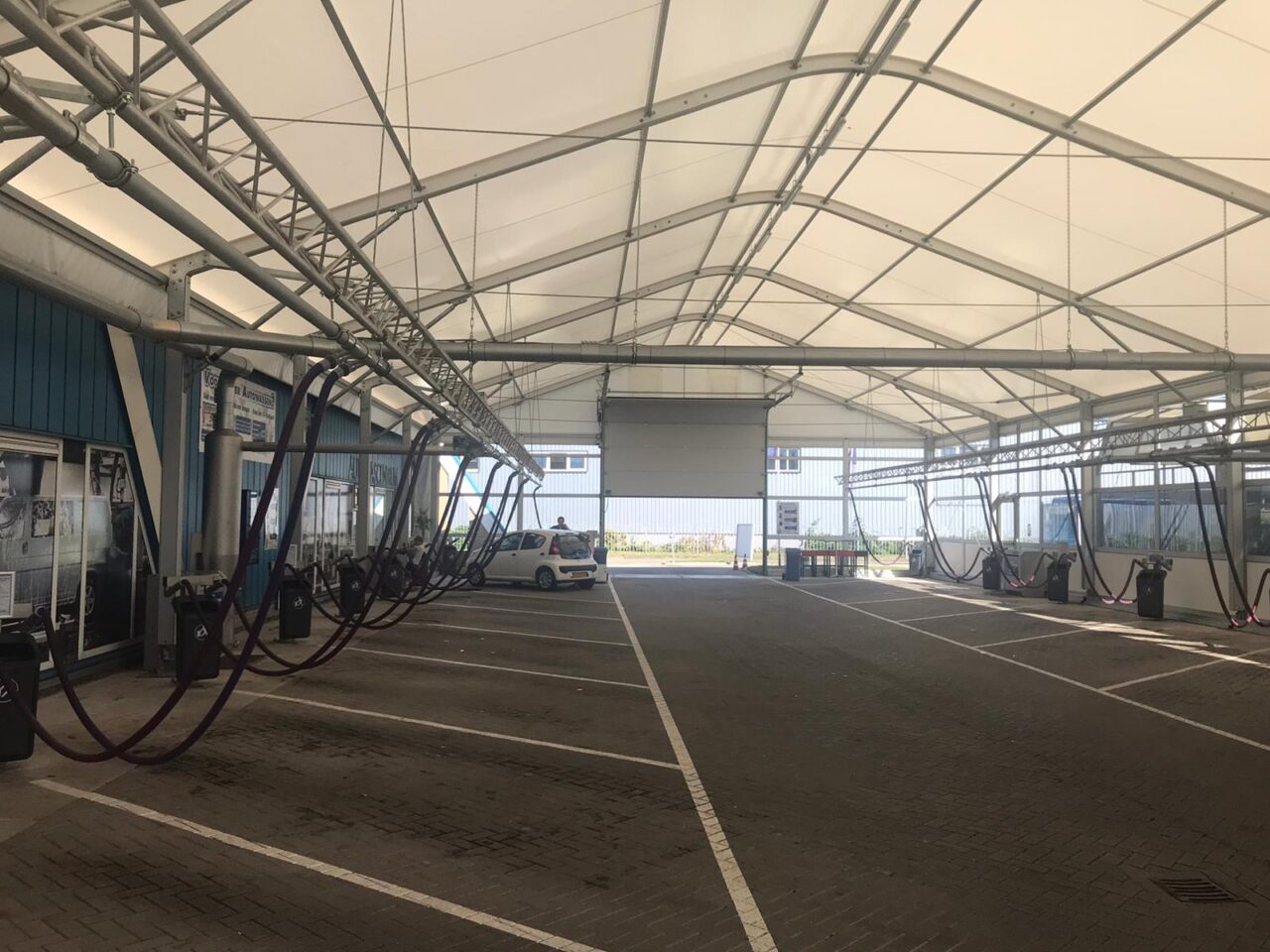 Gewerbehalle für Dienstleistungen - Industriezelte mit Rolltor und Seitenwänden mit Glaspaneelen für Autowachstraße von Zeltverleih Intersettle