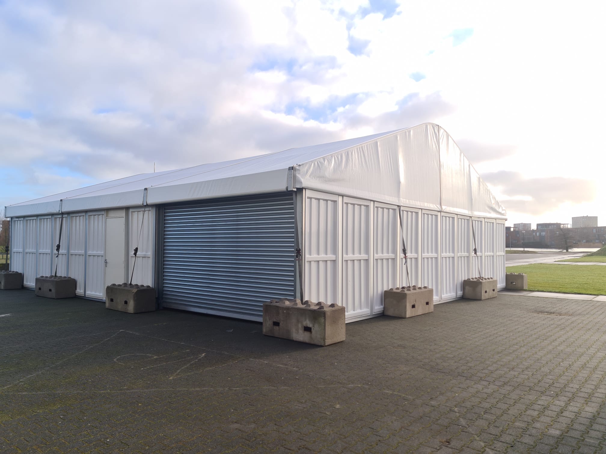 Lagerhalle mit Rolltor und separatem, gesichertem Eingang und Betonverankerungen von Zeltverleih Intersettle