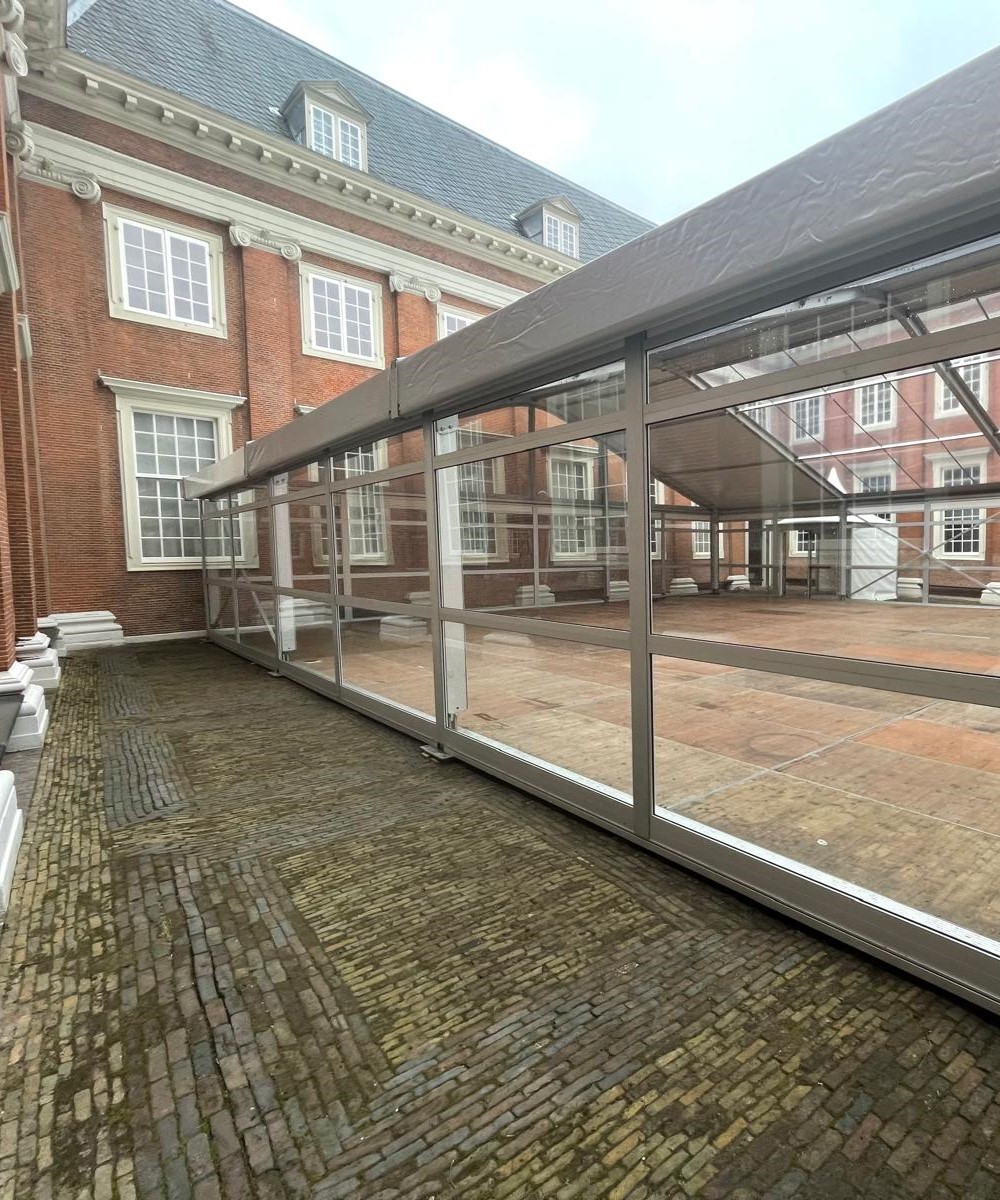 Vision Zelt mit horizontalen Glaspaneelen von Intersettle Zeltverleih im Innenhof des Amsterdam Museum - feierlicher Auftakt zur Sanierung des Museums