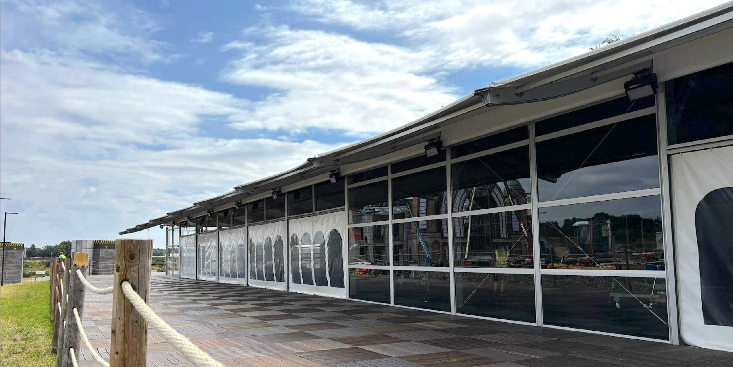 Großzelt Vision Wings von Zeltverleih Intersettle mit horizontaler Glasfassaden und Überdachung der Außenterrasse - VIP-Zelt Platinum Club Parookaville Festival 2025