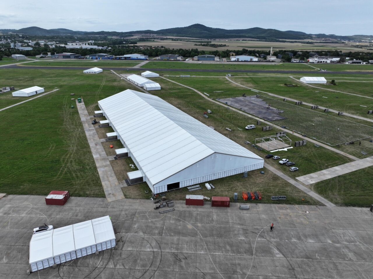 Aufbau Alu Halle und Eventzelte von Intersettle Zeltverleih auf dem ehemaligen Flugplatz Mendig für Großevent Jalsa Salana Deutschland 2025