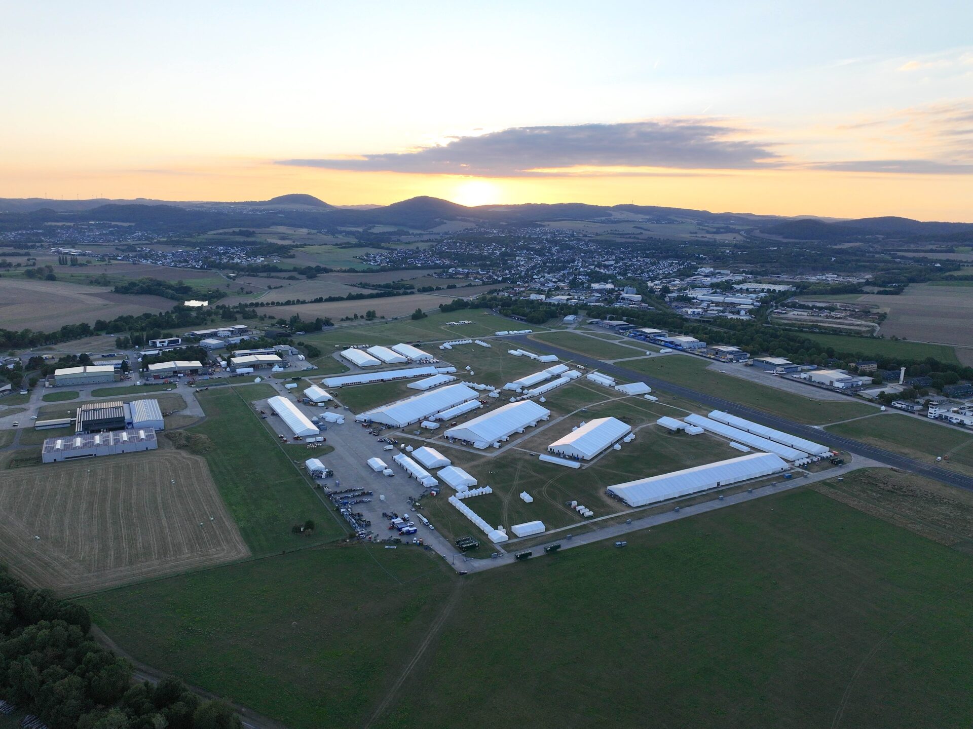 Luftaufnahme Zeltstadt aus Eventzelten, Zelthallen und Pagoden von Intersettle Zeltverleih auf dem ehemaligen Flugplatz Mendig für Großevent Jalsa Salana Deutschland 2025