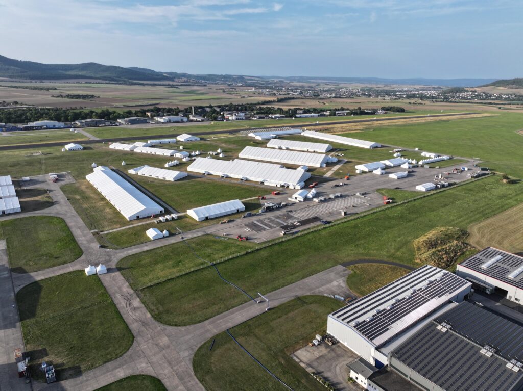 Zeltstadt aus Eventzelten, Zelthallen und Pagoden von Intersettle Zeltverleih auf dem ehemaligen Flugplatz Mendig für Großevent Jalsa Salana Deutschland 2025