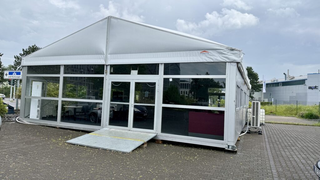 Alu-Halle (10 x 15 m) mit horizontaler Glasfassade von Intersettle Zeltverleih - temporäre Zeltlösung für Interimskantine - Polaroid GmbH in Monheim