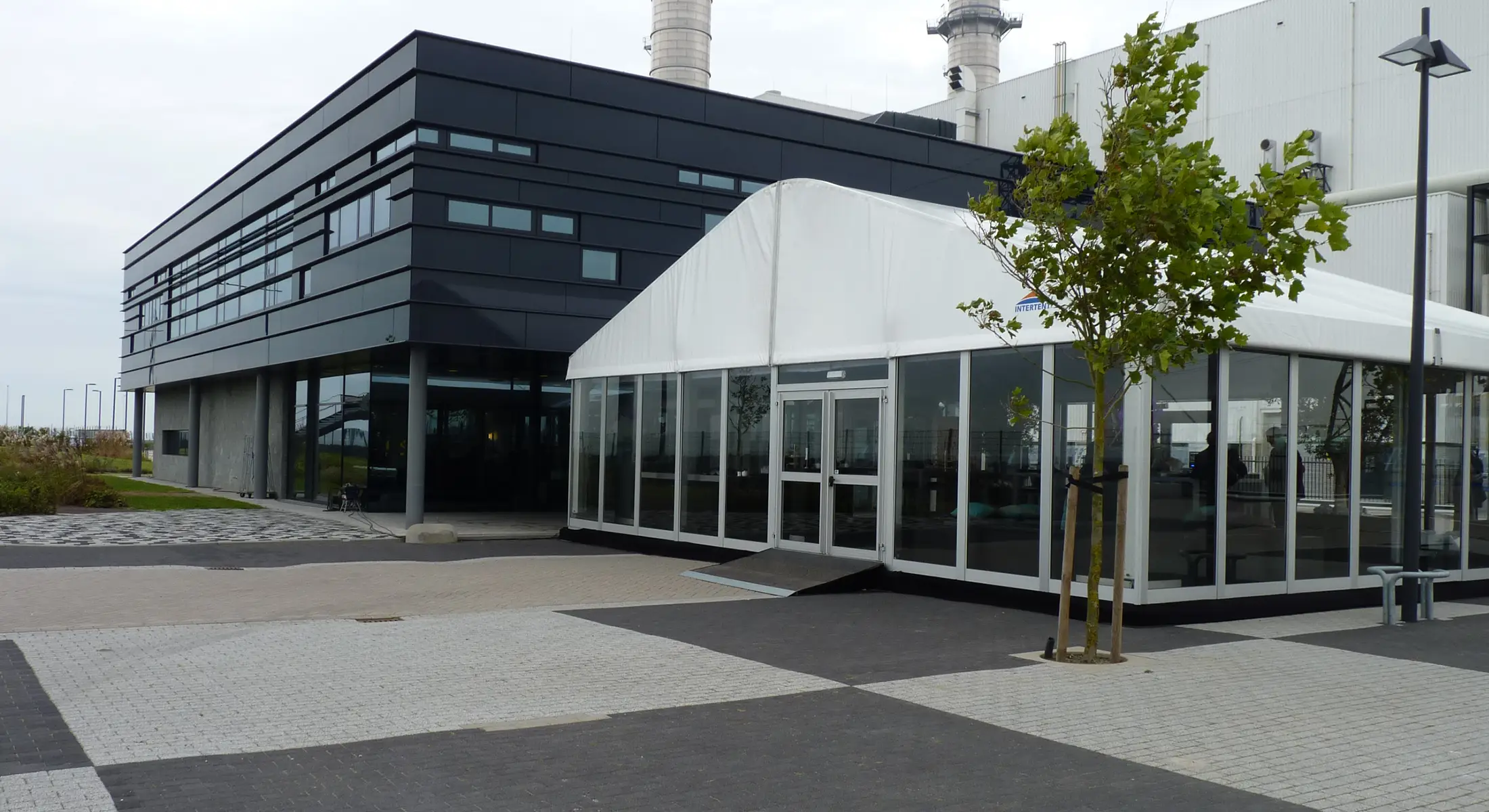 HOMENOW von Intersettle Zeltverleih - Zelthalle für temporäre Büroflächen mit Glaspaneelen